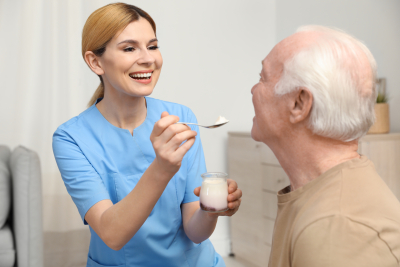 nurse feeding an elderly man