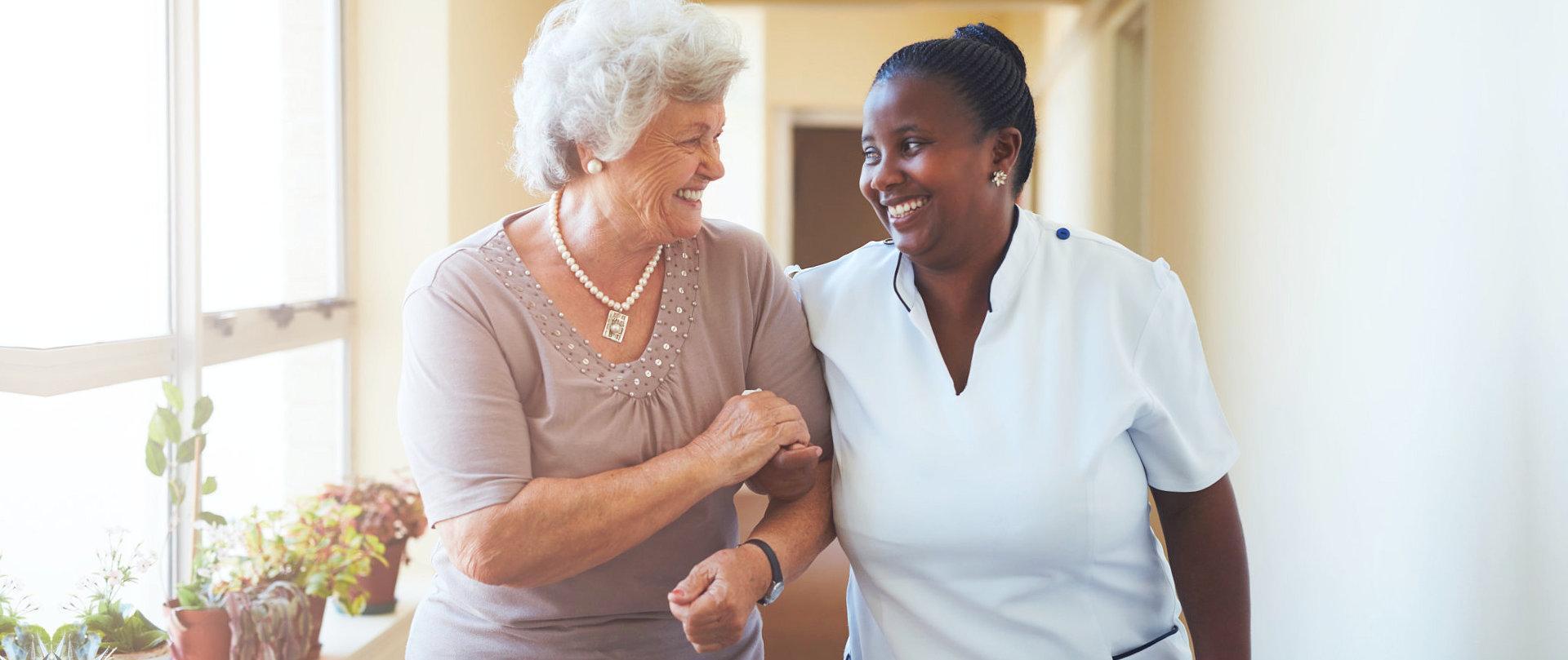 senior woman with caregiver smiling at each other