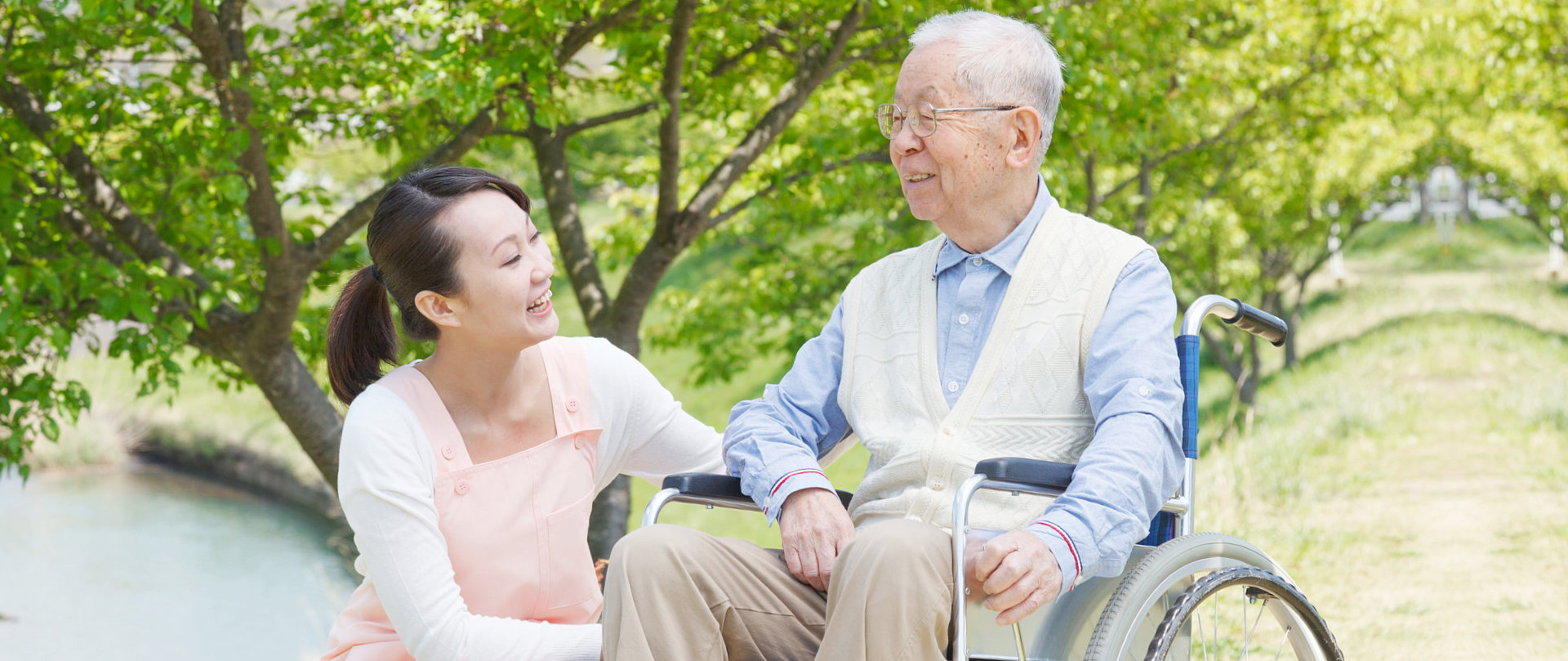 female caregiver with senior man on wheelchair smiling