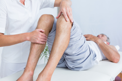 therapist massaging a man's knee